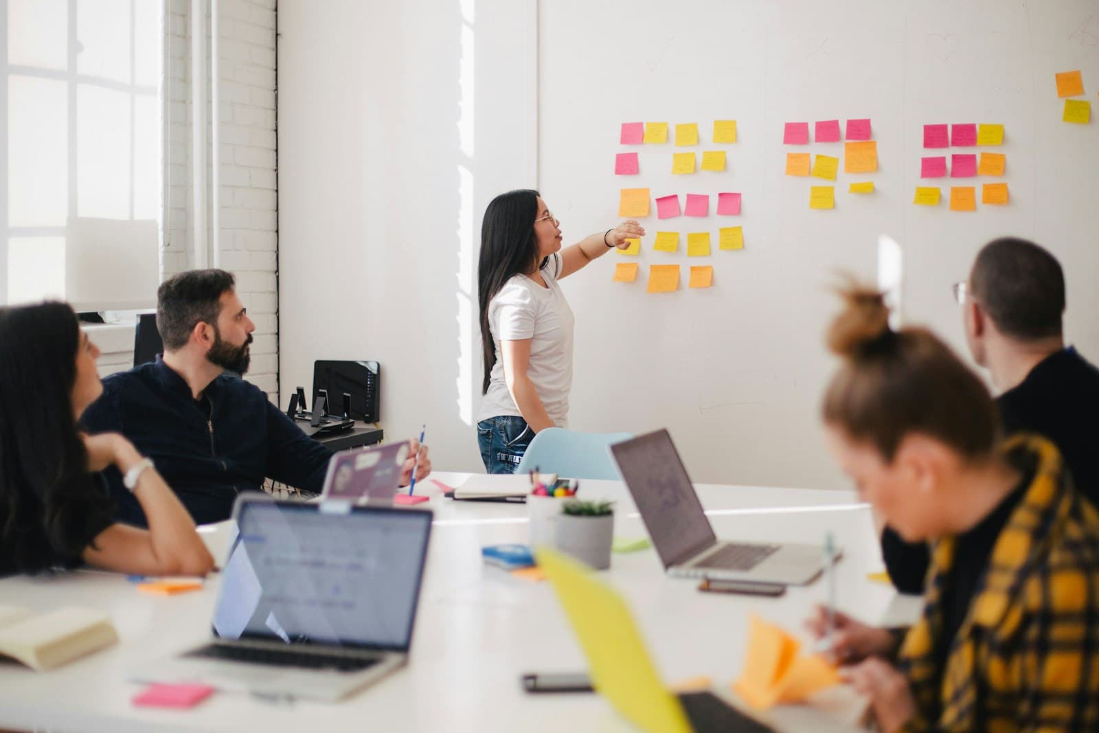 A team mapping a workflow with sticky notes on a whiteboard wall